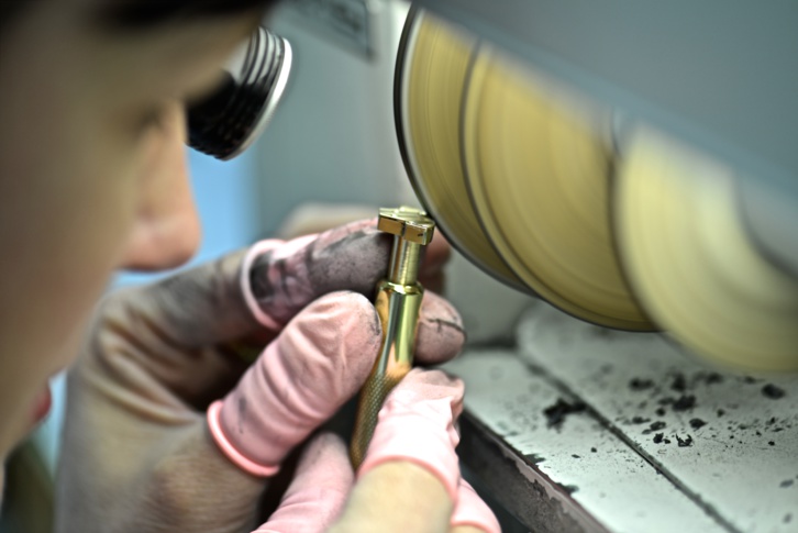 Une opératrice taille manuellement un pont pour une plus grande précision Une opératrice taille manuellement un pont pour une plus grande précision